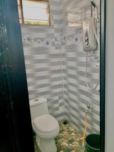 a bathroom with a toilet and a shower at D'NARS HOMESTAY KEMAMAN in Cukai