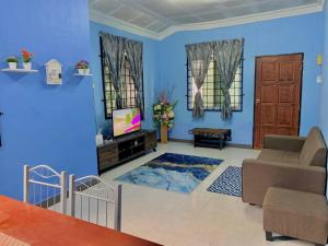 a blue living room with a couch and a tv at D'NARS HOMESTAY KEMAMAN in Cukai