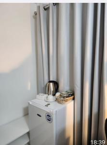 a small refrigerator with a tea pot on top of it at Cozy Guest House in Kent