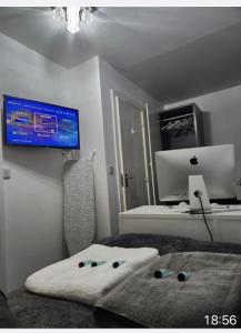 a bedroom with a bed with a computer on the wall at Cozy Guest House in Kent