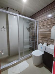 a bathroom with a toilet and a glass shower at RedDoorz @ LQJ Hotel Old Buswang Kalibo in Kalibo