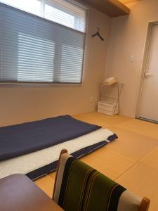 una camera da letto con un letto e una grande finestra di ゲストハウス奈良庵 Nara An a Nara