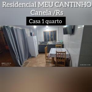 a kitchen with a table and a kitchen with a refrigerator at RESIDENCIAL MEU CANTINHO in Canela