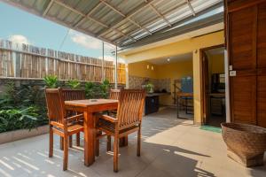 een patio met een houten tafel en 2 stoelen bij Kubu Selat Villa and Glamping in Gianyar