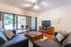 een woonkamer met een bank en een tv bij Norfolk Central-balcony View W Bbq & Secure Park in Fremantle