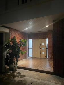 eine Tür in einem Backsteingebäude mit Topfpflanze in der Unterkunft Hotel Ishigaki and Chikonkiya in Ishigaki-jima