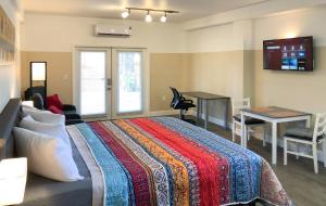 a bedroom with a bed and a desk and a computer at TriLuxe Inn & Studios in Fort Myers