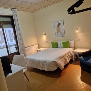 Habitación de hotel con cama grande con almohadas verdes en Hostal Real, en Vigo