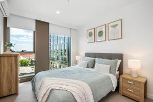 sypialnia z łóżkiem i dużym oknem w obiekcie Metropolitan Vue - Cultural Core of Geelong w mieście Geelong