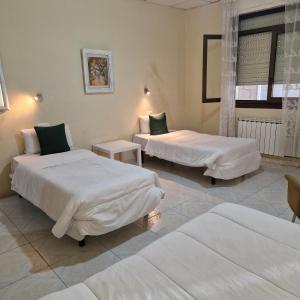 a hotel room with two beds and a window at Hostal Real in Vigo