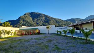 a building with a mountain in the background at PORTO SUÍTES PERUÍBE CHECK-OUT LIVRE aos DOMINGOS in Peruíbe