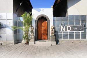 a building with a wooden door with a sign on it at ND LOFT 2 by Kasta Hospitality in Canggu