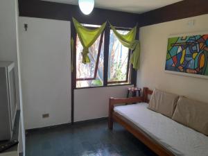 a room with a couch and two windows at Chalés Recanto da Praia in Caraguatatuba