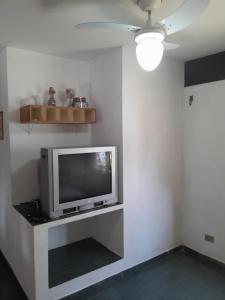 a television sitting on a shelf in a room at Chalés Recanto da Praia in Caraguatatuba