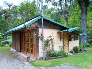 a small white building with a green roof at Riverside Studio- Hush Valley Lodge in Río Blanco