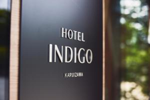 un panneau indiquant l'hôtel indico sur le côté d'un bâtiment dans l'établissement Hotel Indigo Karuizawa, à Karuizawa