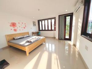 ein Schlafzimmer mit einem Bett in einem Zimmer in der Unterkunft KENPI Homestay in Hue