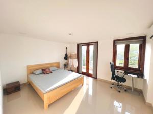 a bedroom with a bed and a desk and a chair at Homestay KENPI in Hue