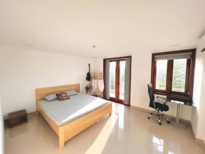 ein Schlafzimmer mit einem Bett, einem Schreibtisch und einem Stuhl in der Unterkunft KENPI Homestay in Hue