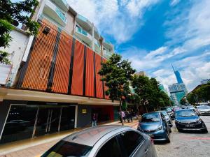 a street with cars parked in front of a building at Cozy Hotel@ KL Sentral in Kuala Lumpur