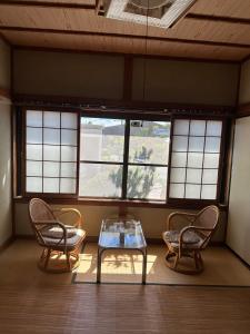 Zimmer mit 2 Stühlen, einem Tisch und Fenstern in der Unterkunft Minpaku Tanaka - Vacation STAY 15255 in Kyōtango
