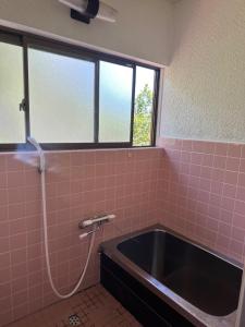 a pink tiled bathroom with a bath tub at Minpaku Tanaka - Vacation STAY 15255 in Kyotango