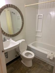 een badkamer met een toilet, een wastafel en een bad bij Franklin Motel in Assiniboia