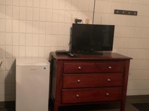 een televisie bovenop een dressoir naast een koelkast bij Franklin Motel in Assiniboia