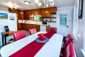 a kitchen with a white table and red chairs at Vintage downtown flat near Holy Hill, Golf &Ski in Hartford