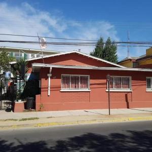 una casa roja al lado de una calle en Residencial La Nona - Villa Alemana en Villa Alemana