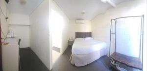 BoulderBroken Hill Hotel的一间带床和淋浴的小卧室