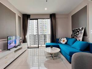 uma sala de estar com um sofá azul e uma televisão em Homely 2BR, Free Carpark @ Direct Link Central Mall, SOGO, Theme Park em Shah Alam