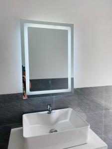 a white sink in a bathroom with a mirror at Khách Sạn Homesaty KV2 in Bình Thủy
