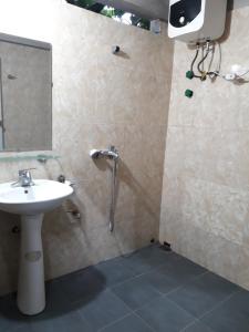 a bathroom with a sink and a shower with a mirror at Ha Giang Faithien Homestay in Ha Giang