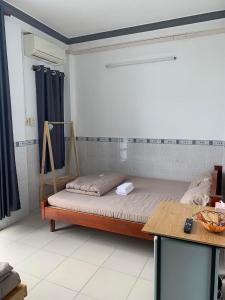 a bedroom with a bed and a table in it at Khách Sạn Homesaty KV2 in Bình Thủy
