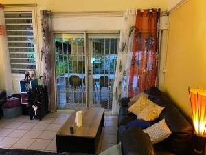 a living room with a couch and a coffee table at Belle maison équipé avec piscine in Mamoudzou +1 photo