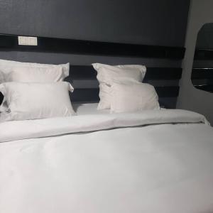 2 łóżka z białymi poduszkami w pokoju w obiekcie Sunrise Center Bonapriso - 107 w mieście Duala