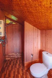 uma casa de banho com um WC branco num quarto de madeira em บ้านลิ้นจี่ 