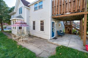 uma casa com um pátio com uma mesa e um guarda-chuva em Vintage downtown flat near Holy Hill, Golf &Ski em Hartford