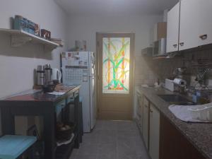 cocina con nevera y puerta con ventana en Las Lavandas ´´Casa de Playa´´ en Playa Unión