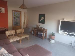 Las Lavandas ´´Casa de Playa´´ في بلاليا أونيون: غرفة معيشة مع أريكة وتلفزيون بشاشة مسطحة