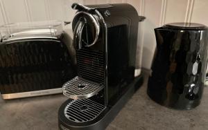 a black toaster oven sitting next to a blender at Áskot Cottages in Hella