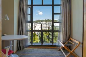 a room with a large window with a view at Hilton Garden Inn Lijiang in Lijiang