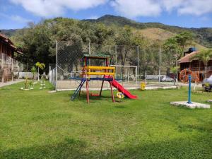 a playground with a slide in the grass at Apto Chocolate Maranduba Ubatuba in Ubatuba