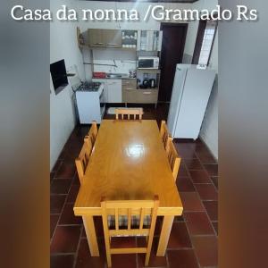 a table and chairs in a room with a kitchen at Casa da NONNA in Gramado