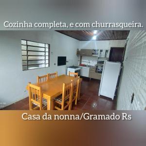 a kitchen with a wooden table and chairs at Casa da NONNA in Gramado