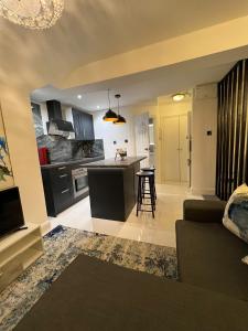 a kitchen and living room with a couch and a table at Modern studio apartment in West Kensington in London