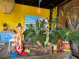 a welcome to a happy hut sign with plants at Hippy Hut Koh Chang in Ko Chang