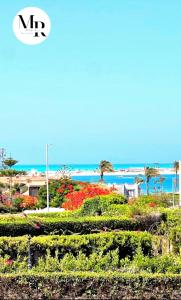 una vista de un jardín con el océano en el fondo en Villa Marina (5) 2nd Row Of The Sea en El Alamein