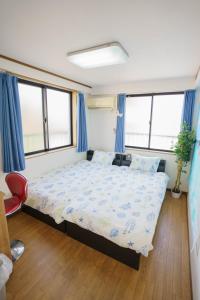 1 dormitorio con 1 cama grande y cortinas azules en BURan House, en Tokio